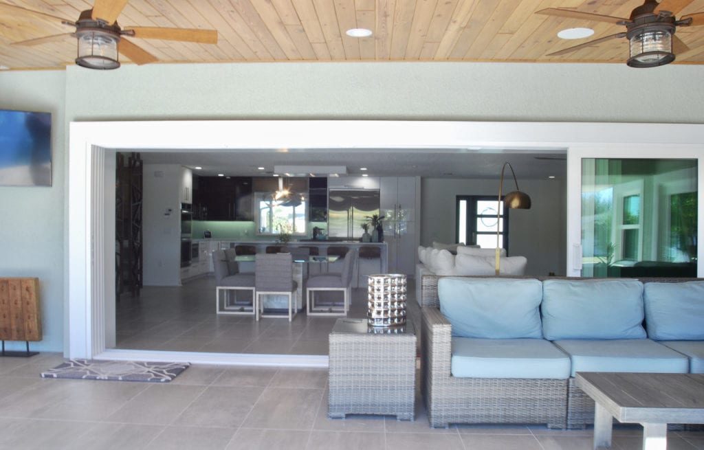 Indoor outdoor living space of beach house; Coastal chic interior design; Michael Gainey Signature Designs
