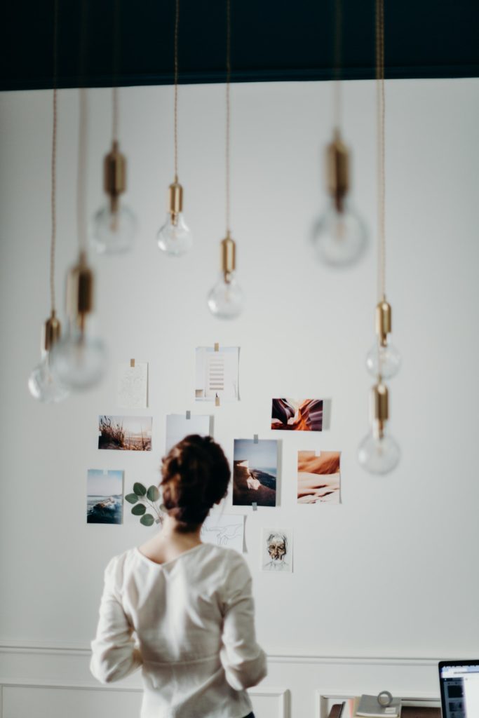 Woman looking at pictures on a wall; interior design inspiration; MGSD